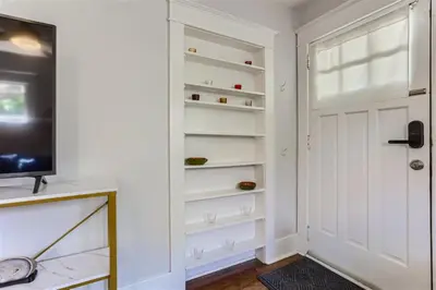 a hallway with a white door and a television at At S. Broadway An Artsy Bungalow Close to DU And Cherry Hills in Englewood