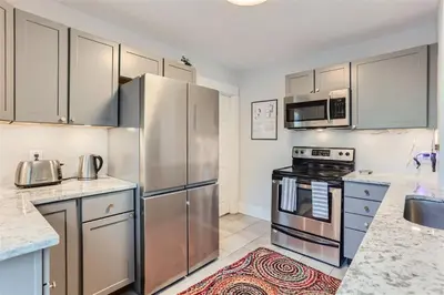 a kitchen with stainless steel appliances and cabinets at At S. Broadway An Artsy Bungalow Close to DU And Cherry Hills in Englewood