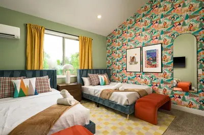 a bedroom with two beds and a wall covered in wallpaper at Accomodate 24 Guests with 2 Rooftops and 2 Hot Tubs and 2 Game Rooms in Denver