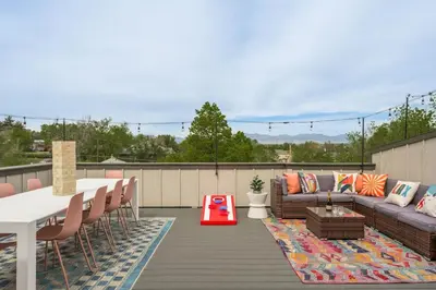 a patio with a couch and a table and chairs at Accomodate 24 Guests with 2 Rooftops and 2 Hot Tubs and 2 Game Rooms in Denver