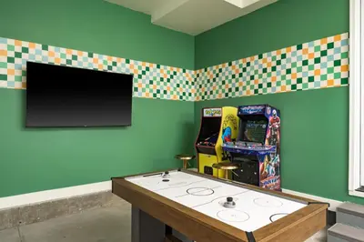 a room with a video game machine and a tv at Accomodate 24 Guests with 2 Rooftops and 2 Hot Tubs and 2 Game Rooms in Denver