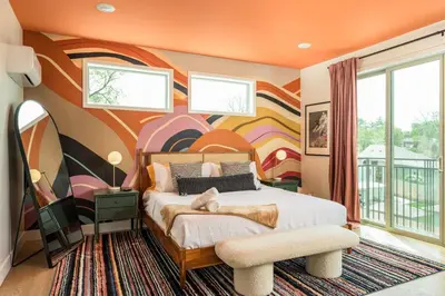a bedroom with a bed with a painting on the wall at Accomodate 24 Guests with 2 Rooftops and 2 Hot Tubs and 2 Game Rooms in Denver