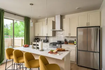 a kitchen with a large island with chairs and a refrigerator at Hot Tub With Rooftop A Game Room And5 Bathrooms in Denver