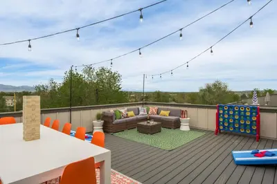 a deck with a couch and a table and chairs at Hot Tub With Rooftop A Game Room And5 Bathrooms in Denver
