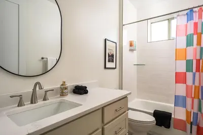 a bathroom with a sink and a toilet and a mirror at Hot Tub With Rooftop A Game Room And5 Bathrooms in Denver