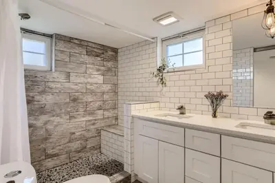 a white bathroom with two sinks and a toilet at A Pet Friendly And Remodeled I Near RiNo Where Sleeps 7 in Denver