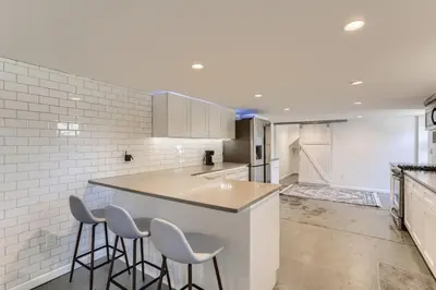 a kitchen with a counter and stools in it at A Pet Friendly And Remodeled I Near RiNo Where Sleeps 7 in Denver