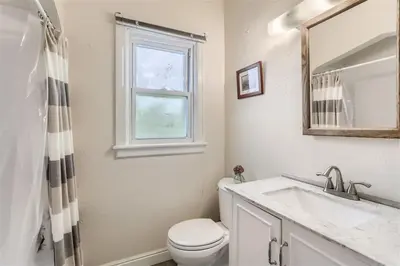 a bathroom with a toilet and a sink and a window at Cozy Duplex near Hospitals and Cherry Creek in Denver in Denver