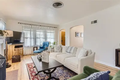 a living room with a white couch and a table at Cozy Duplex near Hospitals and Cherry Creek in Denver in Denver
