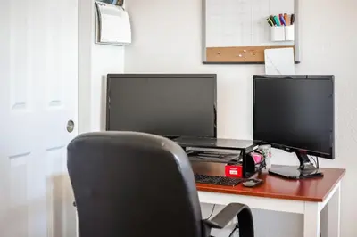 a desk with a computer and a monitor and a chair at Beautiful New Townhome in Denver