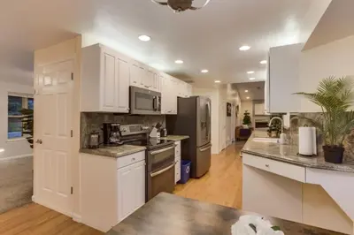 a kitchen with white cabinets and stainless steel appliances at Backyard Oasis Pool Is A Beautiful Home in Arvada