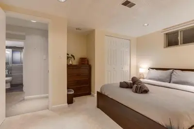 a bedroom with a large bed and a bathroom at Backyard Oasis Pool Is A Beautiful Home in Arvada