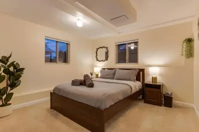 a bedroom with a large bed with two windows at Backyard Oasis Pool Is A Beautiful Home in Arvada