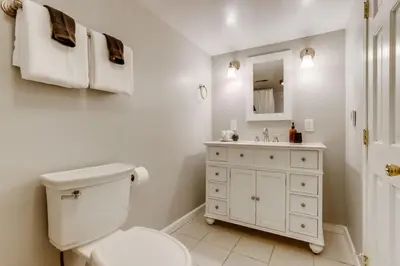 a white bathroom with a toilet and a sink at The Bonsai Bungalow With A Hot Tub And A Game Room in Denver