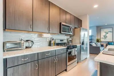 a kitchen with stainless steel appliances and wooden cabinets at Modern And Spacious Townhouse Blocks from Downtown in Denver
