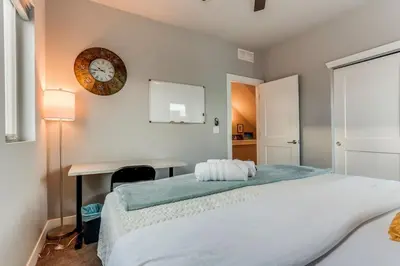 a bedroom with a bed and a desk and a clock at Modern And Spacious Townhouse Blocks from Downtown in Denver