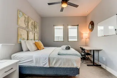 a bedroom with a bed and a desk with a ceiling fan at Modern And Spacious Townhouse Blocks from Downtown in Denver