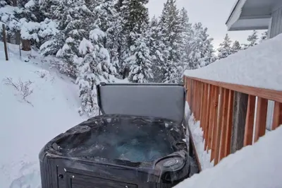 a hot tub in the snow next to a house at Mountain Top Getaway With A Hot Tub in Morrison
