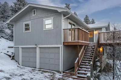 a house with a deck and a garage at Mountain Top Getaway With A Hot Tub in Morrison