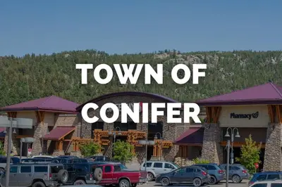 a town of center sign with cars parked in front of a hotel at Mountain Top Getaway With A Hot Tub in Morrison