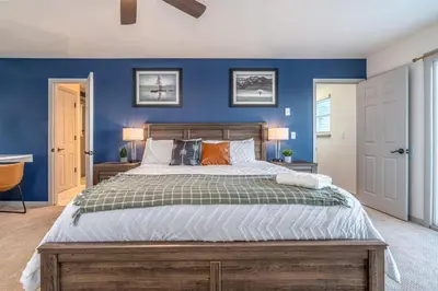 a bedroom with a large bed with blue walls at Mountain Top Getaway With A Hot Tub in Morrison