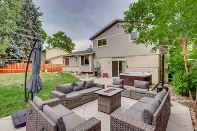 a patio with couches and an umbrella in a yard at A Great Location Modern Home With A Hot Tub in Arvada