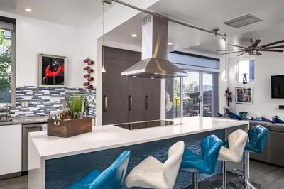 a kitchen with a island with blue and white chairs at Skyline House An Eco Efficient Luxury Home in Denver