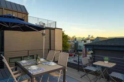 a table and chairs on a balcony with an umbrella at Skyline House An Eco Efficient Luxury Home in Denver