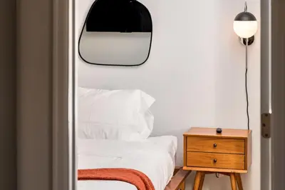 a bedroom with a bed with a mirror and a nightstand at Artist Getaway In Downtown Westminster in Westminster
