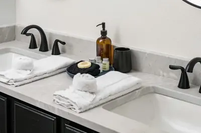 a bathroom sink with towels and a bottle of alcohol at Artist Getaway In Downtown Westminster in Westminster