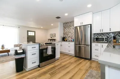 a kitchen with white cabinets and a stainless steel refrigerator at Near Downtown Denver A Huge Home With Two Kitchens in Denver