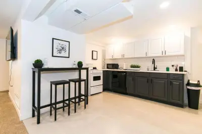 a kitchen with white cabinets and black counter tops at Near Downtown Denver A Huge Home With Two Kitchens in Denver