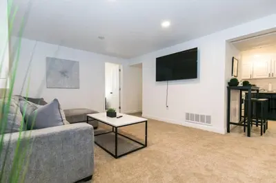 a living room with a couch and a tv on a wall at Cozy With 2 Bath 10 min to Downtown Denver And Fast Wifi in Denver