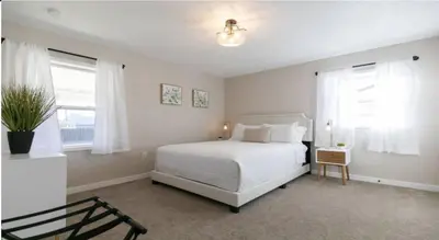 a bedroom with a white bed and two windows at Cozy With 2 Bath 10 min to Downtown Denver And Fast Wifi in Denver