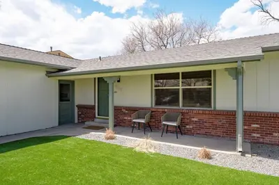 a house with two chairs on a patio at The MCM Movie Manor With A Big Backyard And A Movie Theater in Arvada