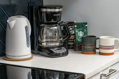 a counter with a coffee maker and cups on it at The MCM Movie Manor With A Big Backyard And A Movie Theater in Arvada