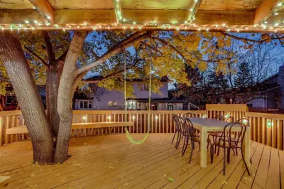 a table and chairs on a deck with a tree at Games Gone Wild Between Red Rocks And Downtown Denver In Arvada in Arvada