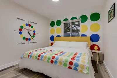 a bedroom with a bed and a clock on the wall at Games Gone Wild Between Red Rocks And Downtown Denver In Arvada in Arvada