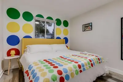 a bedroom with a bed with a colorful comforter at Games Gone Wild Between Red Rocks And Downtown Denver In Arvada in Arvada