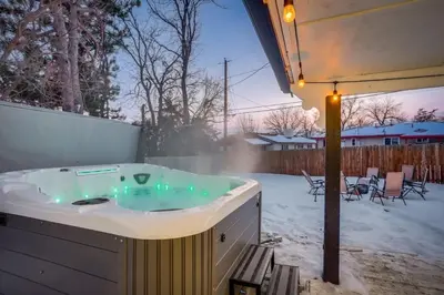 a jacuzzi tub in a backyard in the snow at Groovy Getaway With 4 KING Beds And A Hot Tub in Westminster
