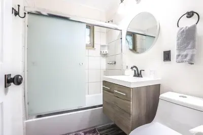 a bathroom with a shower and a toilet and a sink at Groovy Getaway With 4 KING Beds And A Hot Tub in Westminster