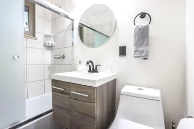 a bathroom with a sink and a mirror and a toilet at Groovy Getaway With 4 KING Beds And A Hot Tub in Westminster