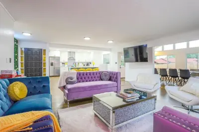 a living room with a purple couch and chairs at Groovy Getaway With 4 KING Beds And A Hot Tub in Westminster