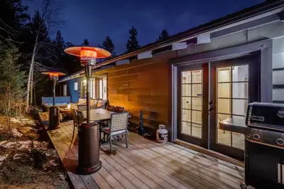 a wooden deck with a table and a grill at Mountain Mansion With A Hot Tub And A Sauna in Morrison