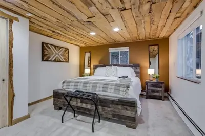 a bedroom with a bed and a wooden ceiling at Mountain Mansion With A Hot Tub And A Sauna in Morrison