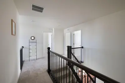 a hallway with a staircase with a clock on the wall at The Stylish Stay Is A Brand New Construction in Thornton