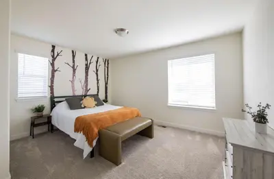 a bedroom with a bed with a tree mural on the wall at The Stylish Stay Is A Brand New Construction in Thornton