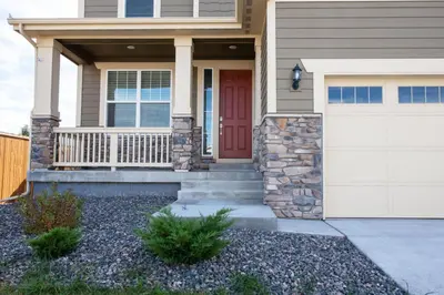 a house with a red door and a garage at The Stylish Stay Is A Brand New Construction in Thornton