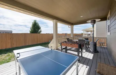 a patio with a ping pong table on a deck at The Stylish Stay Is A Brand New Construction in Thornton