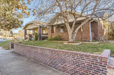a brick house with a tree and a brick wall at Highlands Bungalow With A Back Yard And A Fire Pit in Denver